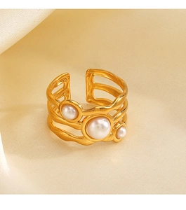 Macro view of a gold wavy layered ring with white pearls on soft silk fabric