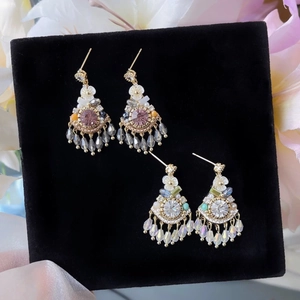 Detail of bohemian crystal flower tassel earrings on black velvet display board