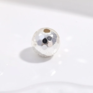 Macro shot of 925 sterling silver beads with laser hammered texture and honeycomb finish