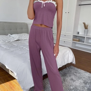 Women's deep purple ribbed pajama set with lace trim and bow in cozy bedroom setting