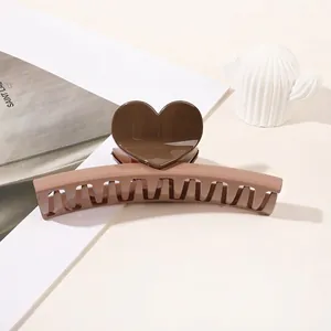 Macro shot of large heart-shaped hair claw clip in brown contrast finish for thick hair