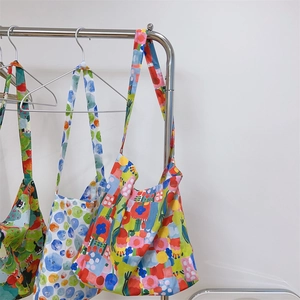 Detailed view of lightweight printed cotton crossbody bags in vibrant floral patterns