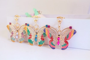 Detail of three creative butterfly keychains with colorful rhinestones and gold plating