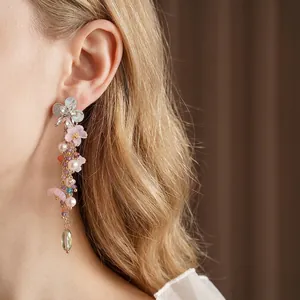 Orecchini a fiore con perle e cristalli indossati da una modella, stile vintage chic
