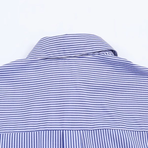 Détail du col et de la texture du tissu de la chemise à rayures bleues et blanches