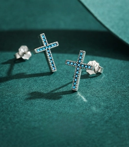 Macro view of S925 sterling silver cross studs featuring turquoise stone inlays
