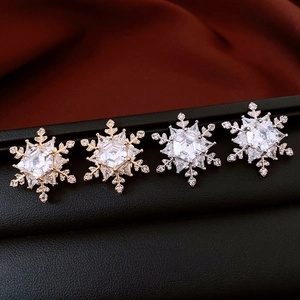 Macro shot of gold and silver hexagon snowflake stud earrings with cubic zirconia