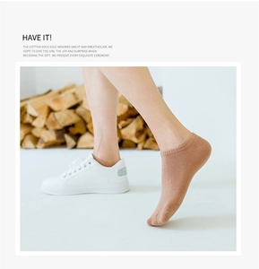 Detail of khaki cotton low-cut ankle sock shown with white sneaker on natural wood background