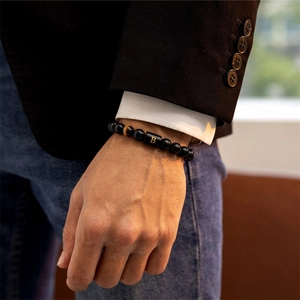 Close-up of a men's obsidian beaded bracelet with tiger eye stone and gold letter B charm