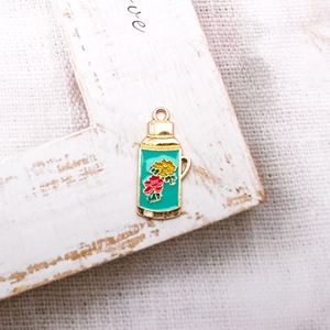 Detail shot of a vintage green thermos enamel alloy charm with colorful floral patterns
