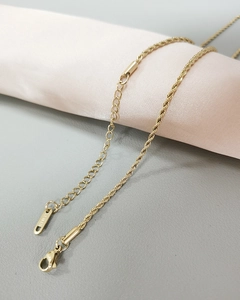 Detailed macro view of gold stainless steel twist chain necklace with lobster clasp closure