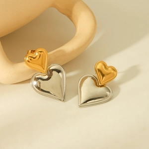 Detail of two-tone gold and silver heart earrings with polished metal finish