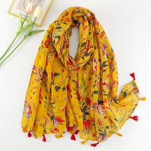 Detail view of yellow boho cotton linen scarf with floral print and tassel edges
