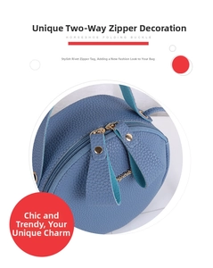 Detail view of the blue grainy leather round bag with double zippers and gold metal rivets