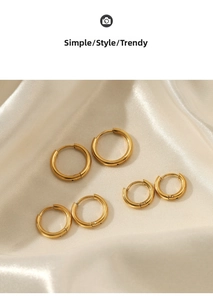 Three pairs of polished gold hoop earrings in small, medium and large sizes on silk fabric