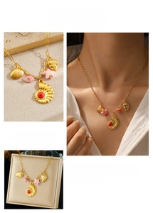 Close-up of gold seashell and pink star pendants on a delicate stainless steel chain