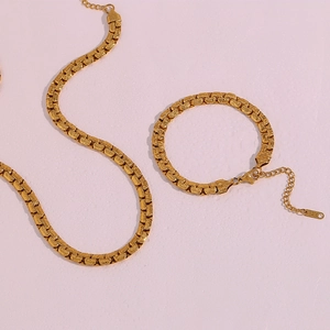 Detailed view of gold-plated geometric flat chain necklace and bracelet set with lobster clasp