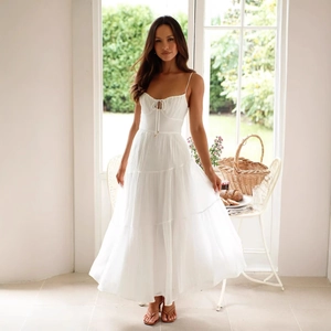 Robe longue blanche élégante avec buste à nouer et jupe à volants pour l'été