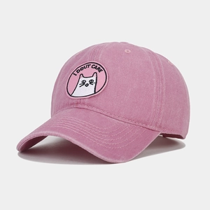 Close-up of pink washed cotton baseball cap with cat embroidery and I DOUT CARE text
