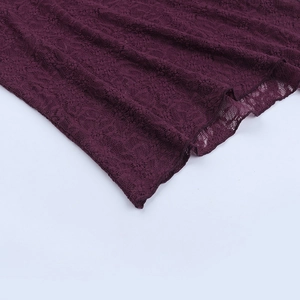Detailed close-up of dark purple lace fabric with intricate floral crochet and wavy edges