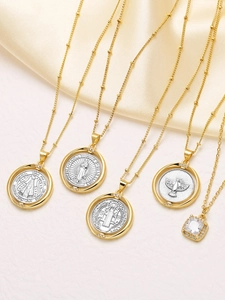 Detalle de collares religiosos bañados en oro de 18k sobre seda de color champán