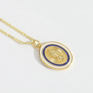 Macro shot of oval gold Virgin Mary pendant with white and blue enamel religious details