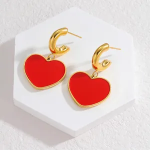 Elegant gold titanium steel C-hoop earrings with polished red heart-shaped pendant charms