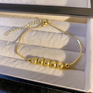 Minimalist gold snake chain bracelet with textured beads displayed in a white gift box