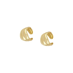 Macro detail of gold-plated ear cuffs with unique wavy texture and polished finish
