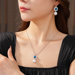 Dettaglio di collana e orecchini vintage in argento con pietre preziose blu e perle sul modello