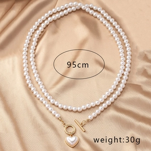 Detail view of 95cm double-layer pearl necklace with heart pendant and OT buckle on silk