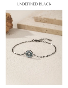 Macro detail of S925 sterling silver black chain bracelet with turquoise evil eye pendant
