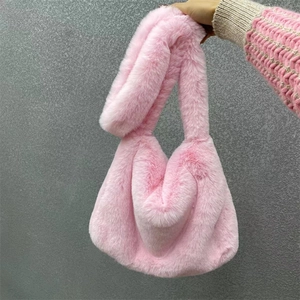 Close-up of soft pink faux fur tote bag with wide shoulder strap for autumn and winter