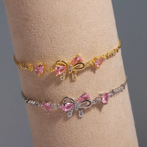Detail of adjustable bow bracelets in gold and silver with pink heart zirconia stones