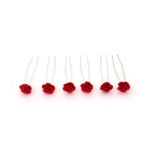 Close-up of red velvet rose U-shaped hair pins with silver metal prongs for bridal styling