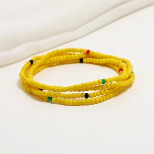 Detail of vibrant yellow beaded waist chain with colorful accents for beach bikini outfits