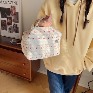 Détail de la trousse à maquillage matelassée en coton fleuri avec double fermeture