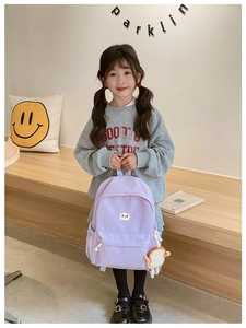 Detail view of purple kids backpack with cute cat patch and plush toast pendant