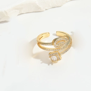 Detailed close-up of golden open ring featuring square zircon and sparkling leaf motif