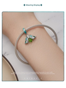 Detail of s925 silver mesh bracelet with green enamel moth pendant worn on wrist