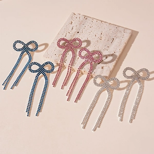 Boucles d'oreilles nœud élégantes avec pompons et cristaux en bleu, rose et argent