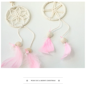 Detail of Christmas dreamcatcher ornament with pink feathers and cotton weaving details