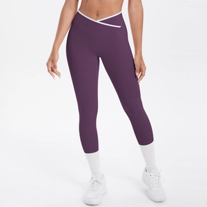 Détail du legging de yoga taille haute avec ceinture croisée en V et liseré blanc