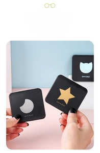 Close-up of portable square black mirrors with gold star and moon patterns for travel