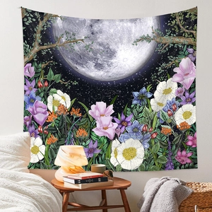Tapisserie lune et fleurs accrochée au-dessus d'un lit dans une chambre bohème