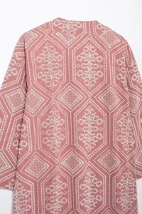 Detailed back view of pink cardigan featuring white geometric embroidery and floral patterns