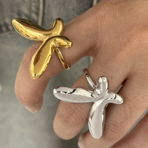 Exaggerated abstract butterfly rings in mirror polished gold and silver on fingers
