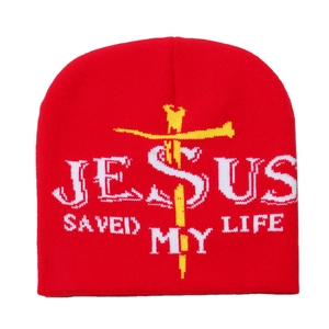 Détail du bonnet rouge avec texte Jesus Saved My Life blanc et motif de croix jaune