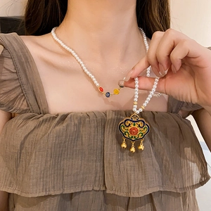 Detail einer Vintage Perlenkette mit Emaille Ruyi-Schloss und Goldglöckchen