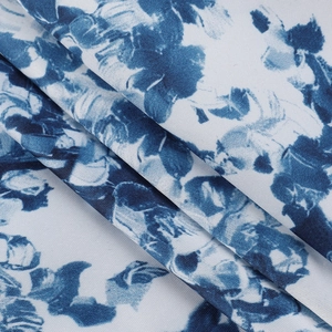 Gros plan de la texture du tissu imprimé floral bleu sur une robe d'été blanche lisse